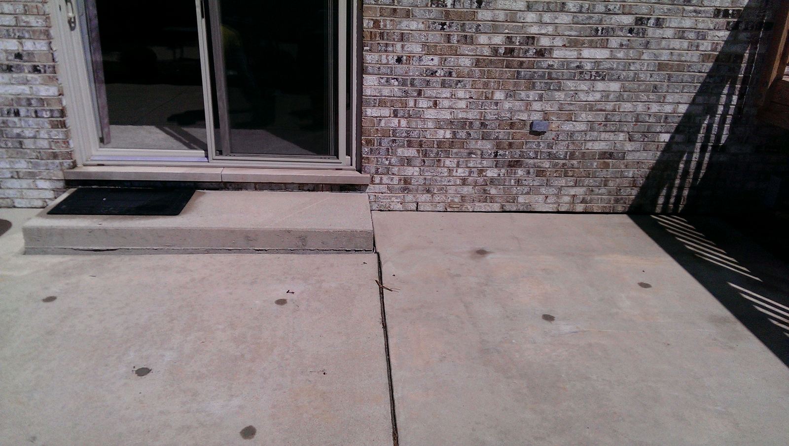 Level concrete walkway along the side of a house